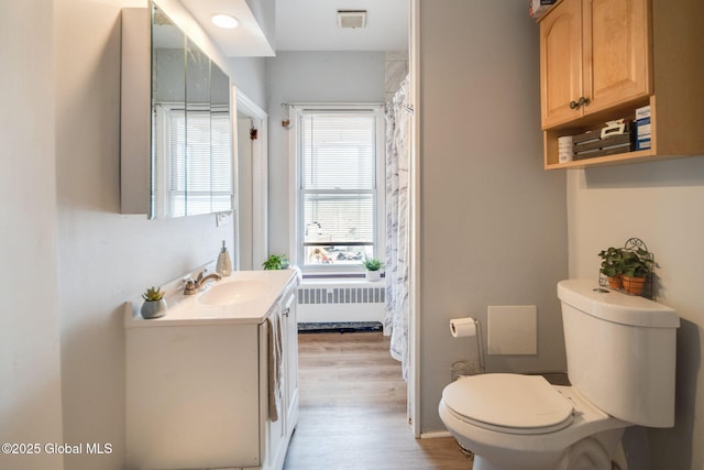 full bathroom with visible vents, toilet, radiator heating unit, wood finished floors, and vanity