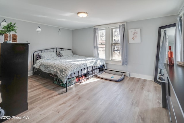 bedroom with wood finished floors, baseboards, baseboard heating, and ornamental molding