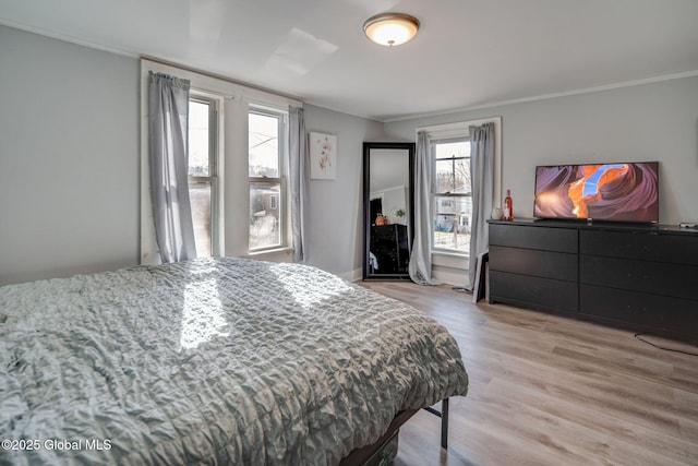 bedroom with crown molding and light wood-style floors