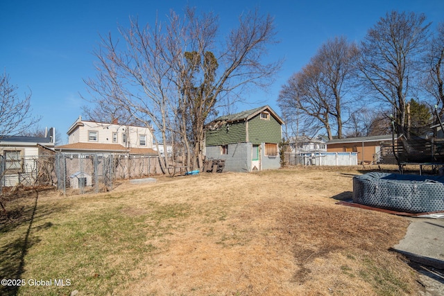 view of yard featuring an outdoor pool, an outbuilding, a storage shed, and fence