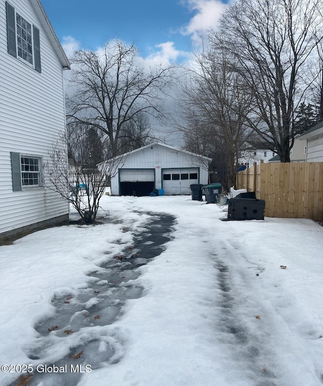 exterior space with an outbuilding, a detached garage, and fence