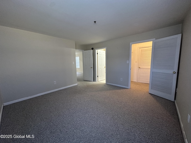 carpeted empty room featuring baseboards