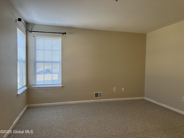 spare room with visible vents, carpet floors, and baseboards