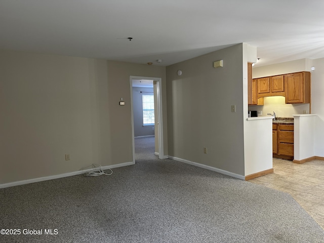 unfurnished living room with baseboards