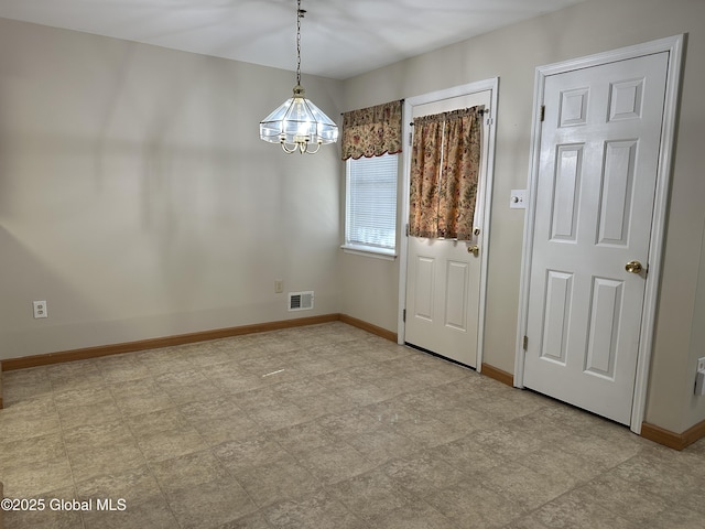 unfurnished dining area with visible vents, baseboards, and a notable chandelier