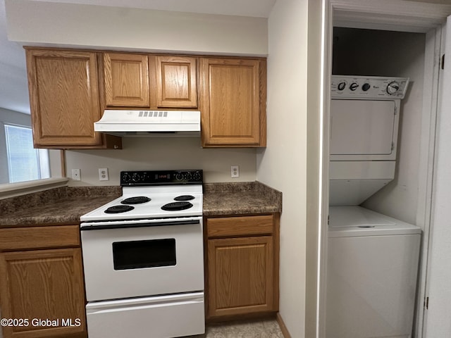 kitchen featuring under cabinet range hood, dark countertops, stacked washer / drying machine, and white range with electric cooktop