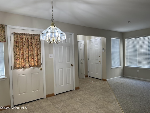 foyer with baseboards and an inviting chandelier