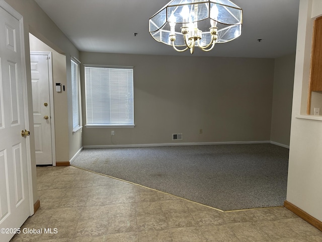 unfurnished room featuring a chandelier, visible vents, baseboards, and carpet