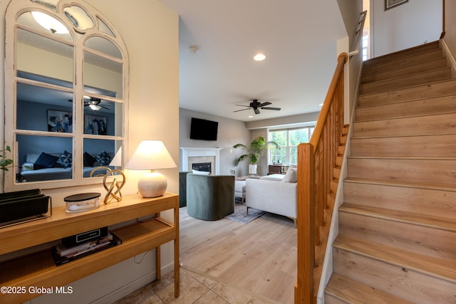 interior space featuring a fireplace, wood finished floors, recessed lighting, and a ceiling fan