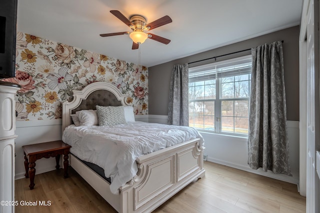 bedroom with baseboards, ceiling fan, wallpapered walls, and light wood-type flooring
