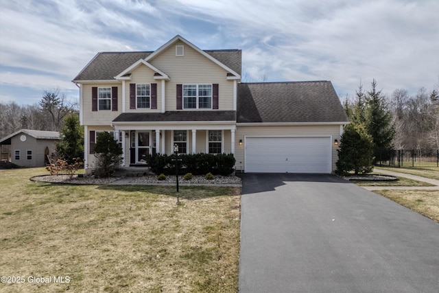traditional-style house with aphalt driveway, fence, a garage, a front yard, and a shingled roof
