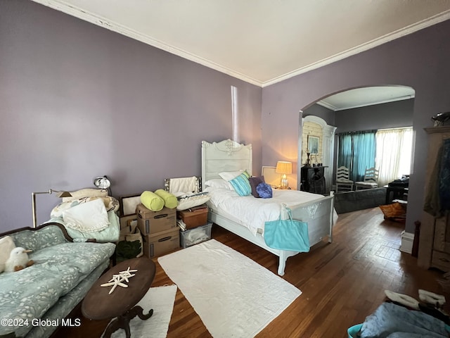 bedroom with crown molding, wood finished floors, and arched walkways