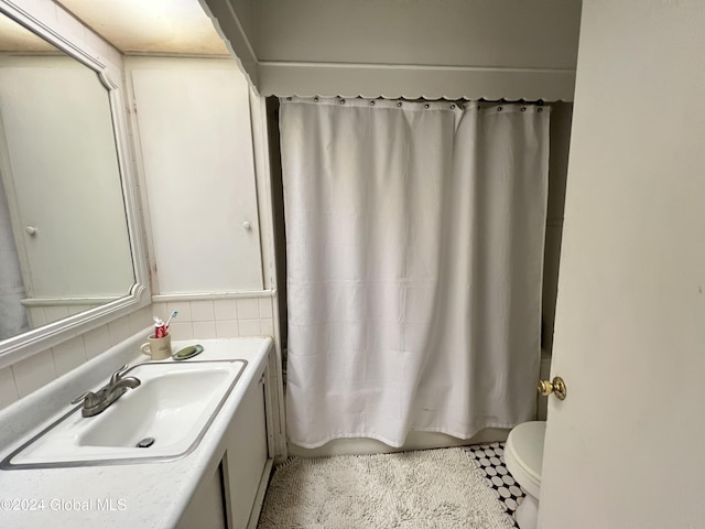 bathroom with decorative backsplash, shower / bath combination with curtain, toilet, and vanity