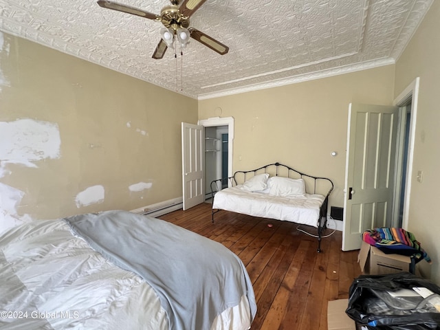 bedroom with a ceiling fan, an ornate ceiling, ornamental molding, hardwood / wood-style flooring, and a baseboard heating unit