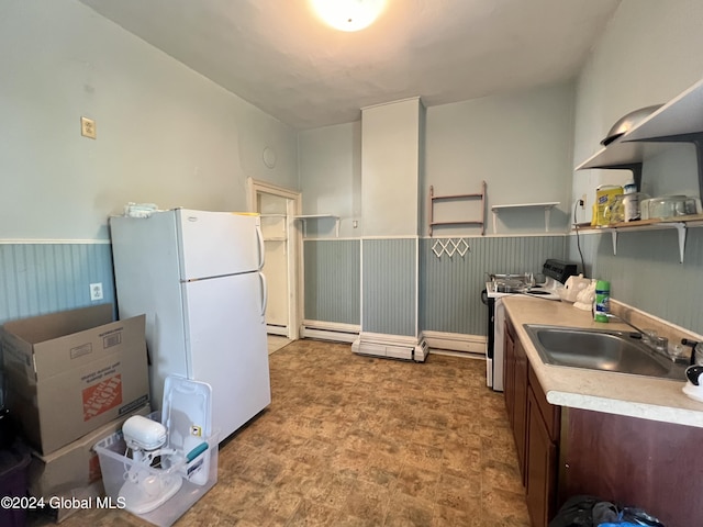 kitchen featuring a wainscoted wall, a sink, freestanding refrigerator, light countertops, and range