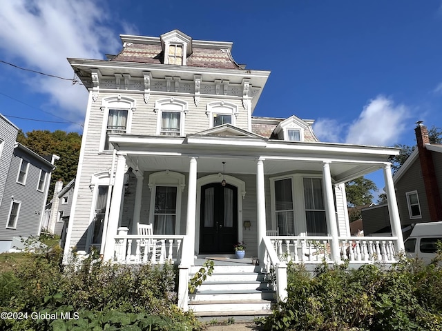 victorian home featuring mansard roof and a porch