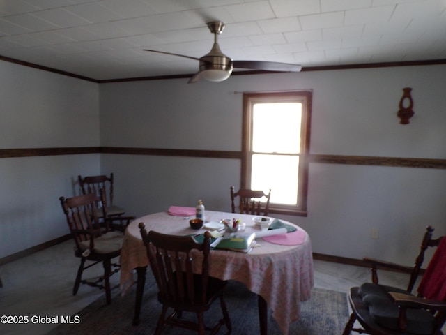 dining space with ceiling fan, baseboards, and ornamental molding