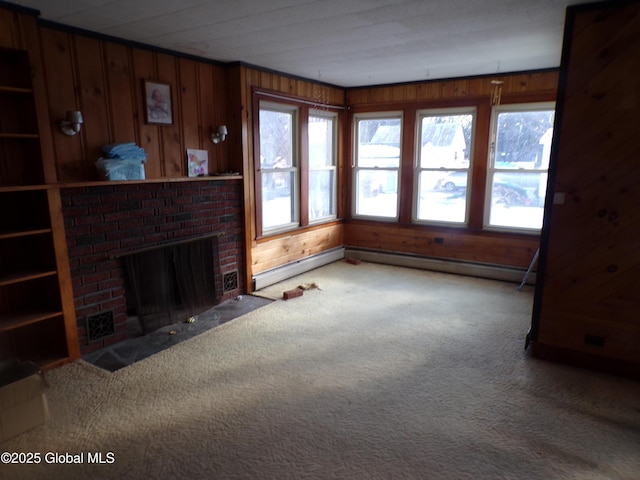 unfurnished living room with a baseboard radiator, a fireplace, carpet flooring, and wood walls