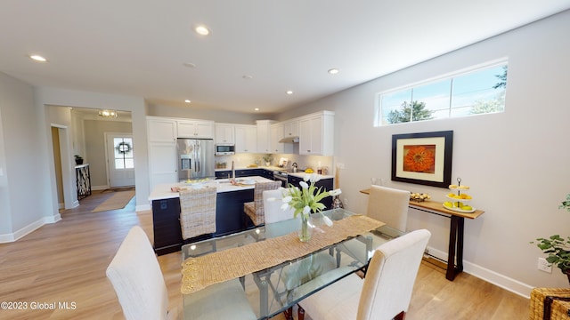 dining room with recessed lighting, baseboards, and light wood-style flooring