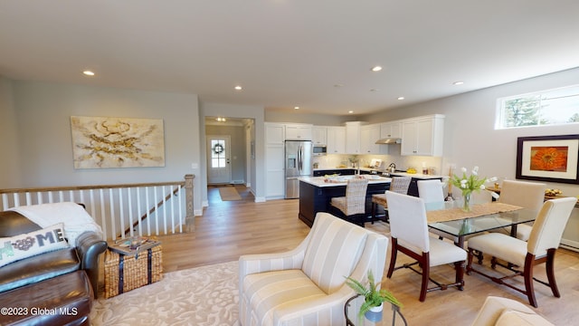 living area with recessed lighting, baseboards, and light wood-style floors