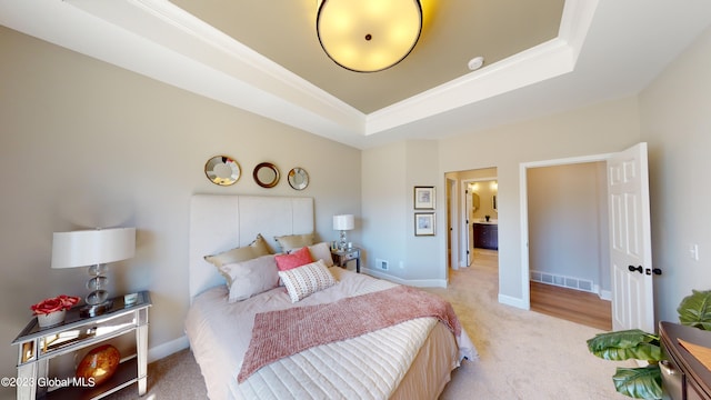 bedroom featuring baseboards, visible vents, carpet floors, a tray ceiling, and ornamental molding