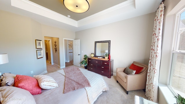 bedroom with a tray ceiling, baseboards, light colored carpet, and crown molding