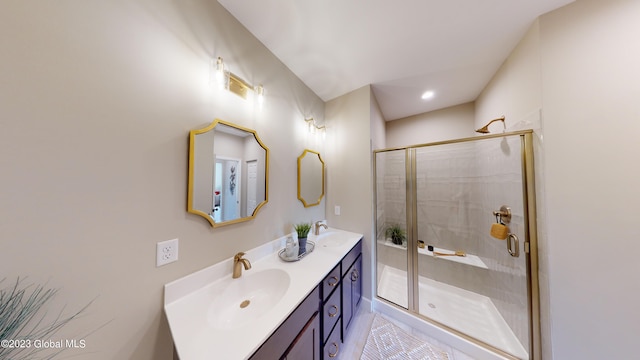 full bath featuring a shower stall, double vanity, and a sink