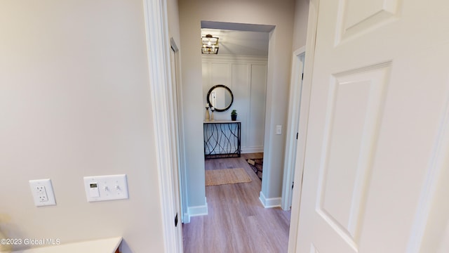 hall with baseboards and light wood finished floors