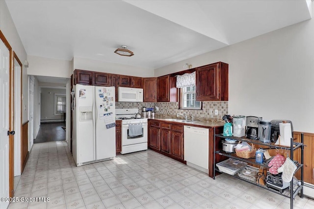 kitchen with decorative backsplash, white appliances, light floors, and a sink