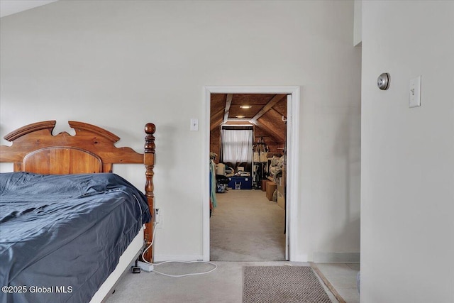 bedroom with baseboards, lofted ceiling, and carpet floors