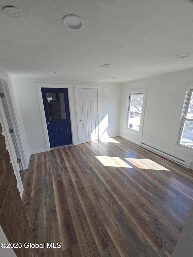 interior space featuring a baseboard heating unit and wood finished floors