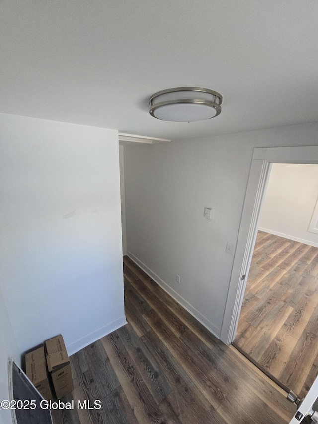 empty room featuring dark wood-type flooring and baseboards