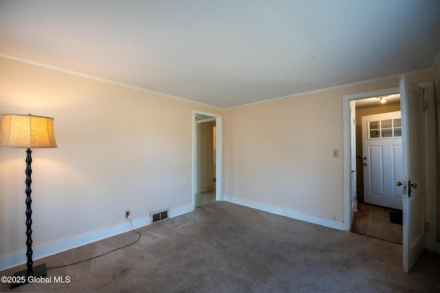 spare room with visible vents, carpet flooring, crown molding, and baseboards