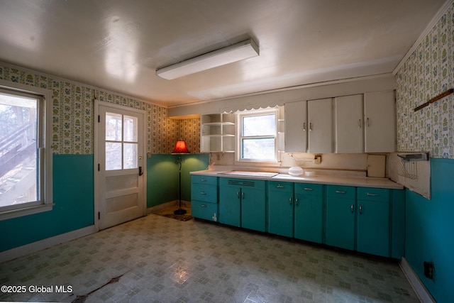 kitchen with light floors, wallpapered walls, green cabinets, and open shelves