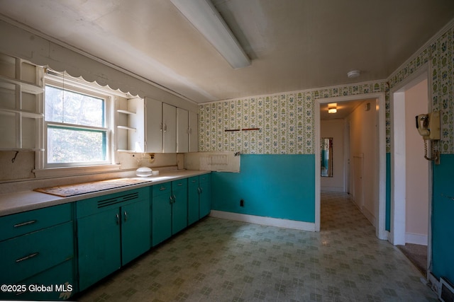 kitchen with wallpapered walls, green cabinetry, light floors, light countertops, and open shelves