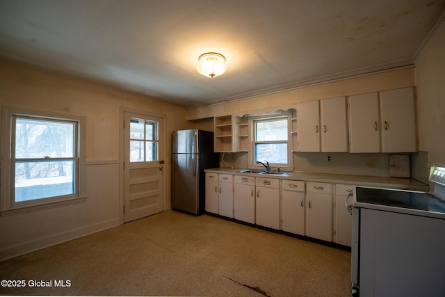 kitchen with open shelves, freestanding refrigerator, a sink, white cabinets, and white range with electric stovetop