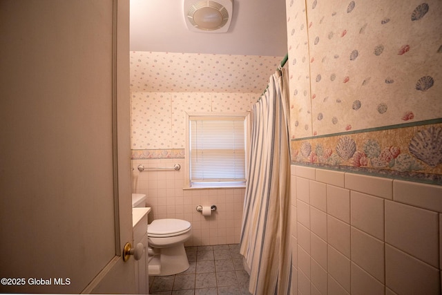 full bathroom featuring tile patterned flooring, a wainscoted wall, wallpapered walls, and tile walls