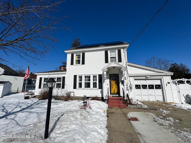 view of front of property featuring a gate, a garage, solar panels, and fence