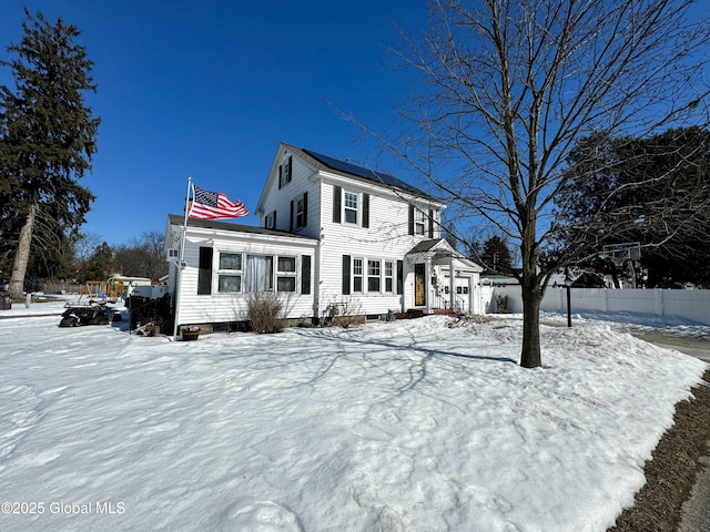 view of front of house featuring solar panels and fence