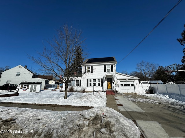 view of front of property featuring driveway, a garage, and fence