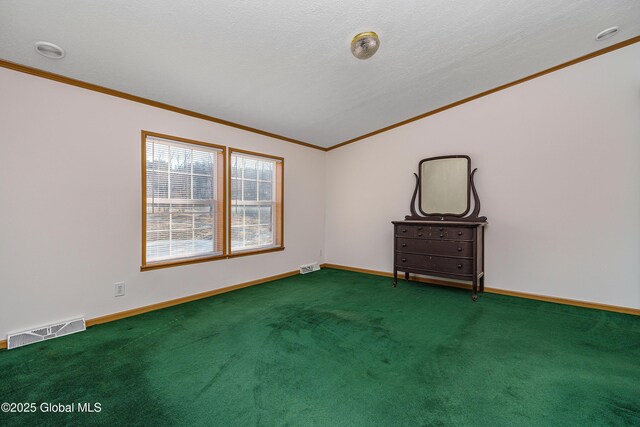 spare room with visible vents, a textured ceiling, carpet flooring, crown molding, and baseboards