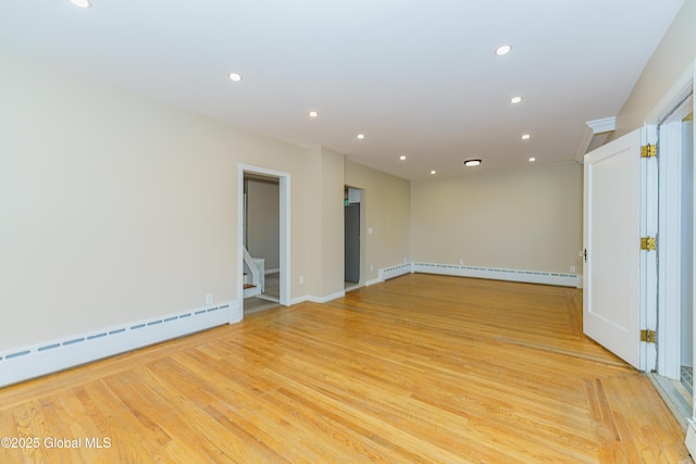 empty room featuring baseboard heating, recessed lighting, light wood-type flooring, and a baseboard radiator