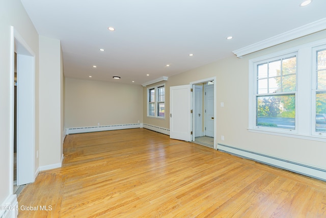 empty room featuring baseboard heating, recessed lighting, light wood-type flooring, and a baseboard radiator