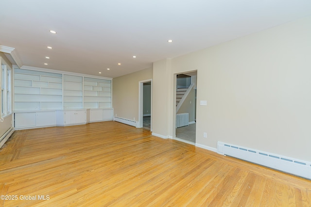 empty room featuring recessed lighting, baseboard heating, and light wood finished floors