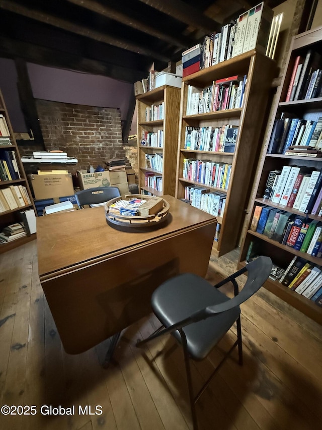47 Church St, Amsterdam, NY 12010 - home office featuring hardwood / wood-style floors, wall of books, and brick wall