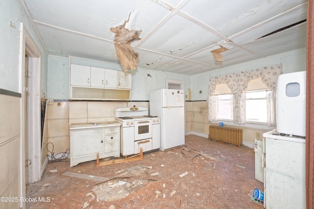 kitchen with washer / clothes dryer, radiator heating unit, white appliances, white cabinets, and light countertops