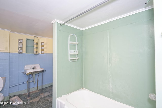 full bathroom with tub / shower combination, toilet, and tile walls