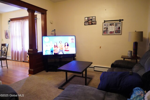 living room with ornate columns, wood finished floors, and baseboard heating