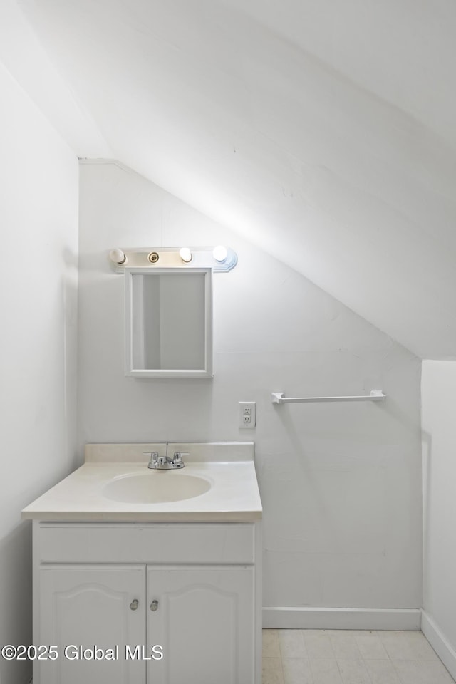 bathroom featuring vanity and lofted ceiling