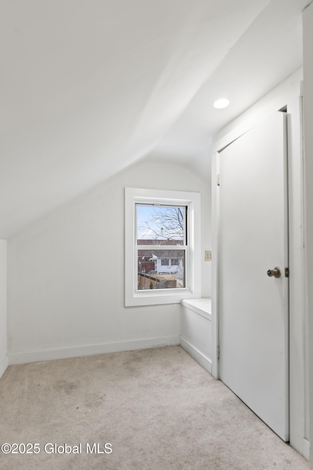 additional living space with carpet flooring and vaulted ceiling